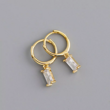 将图片加载到图库查看器,mini gold on silver huggie hoops with rectangular cubic zirconia claw set stone drop handing from the circular hoop pictured on grey background