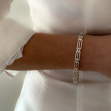 Load image into Gallery viewer, chunky heavy sterling silver gate bracelet, handmade with strong clasp. Bracelet is been worn by model on bare white skin and plain white shirt on white background
