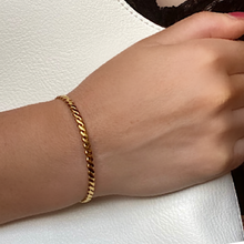 Load image into Gallery viewer, A Gold Plated Weave Cuff Bracelet on a women&#39;s wrist clutching a white bag
