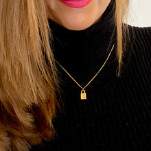 Load image into Gallery viewer, Mini 18 carat Gold plated plain padlock on a strong gold curb chain 18in. worn by a model wearing black jumper, red lipstick and brown straight hair
