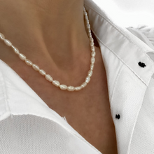Загрузить изображение в средство просмотра галереи, cultured pear necklace, single row with gold clasp worn by lady in white open buttoned shirt on white background

