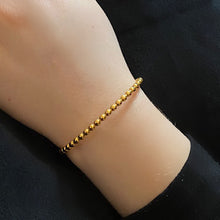 Load image into Gallery viewer, Gold Beaded Cuff Bracelet on a women&#39;s wrist with a black background 
