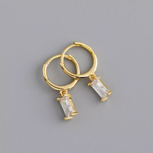 Load image into Gallery viewer, mini gold on silver huggie hoops with rectangular cubic zirconia claw set stone drop handing from the circular hoop pictured on grey background
