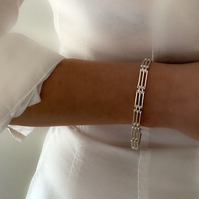 chunky heavy sterling silver gate bracelet, handmade with strong clasp. Bracelet is been worn by model on bare white skin and plain white shirt on white background