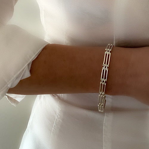 chunky heavy sterling silver gate bracelet, handmade with strong clasp. Bracelet is been worn by model on bare white skin and plain white shirt on white background